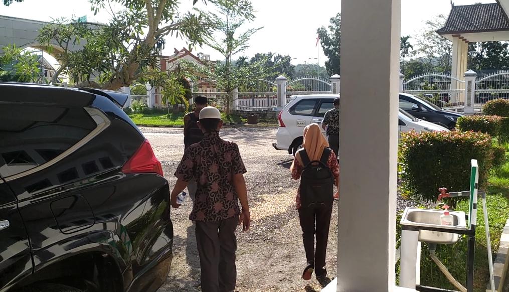 Kades Penyengat Olak Rutomi keluar meninggalkan kantor Kejari Muaro Jambi.(Raden Hasan Efendy)