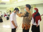 Wakil Rektor III Bidang Kemahasiswaan dan Kerja Sama, Dr. Bahrul Ulum, MAK memasangkan masker kepada peserta.(Foto:Bujangdek)