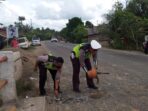 Aksi Bripka Doni dan Bripka Suhendri saat memperbaiki jalan yang berlubang di atas jembatan Desa Berembang.