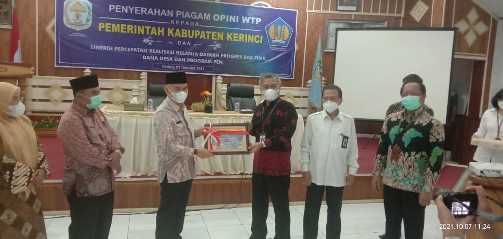 Bupati Adirozal menerima plakat dan piagam opini WTP dari Kepala Kanwil Ditjen Perbendaharaan Provinsi Jambi Supendi.