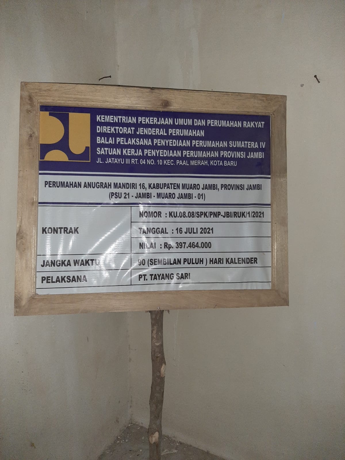 papan merek proyek jalan lingkungan di Perumahan Anugerah Mandiri disimpan dalam rumah.