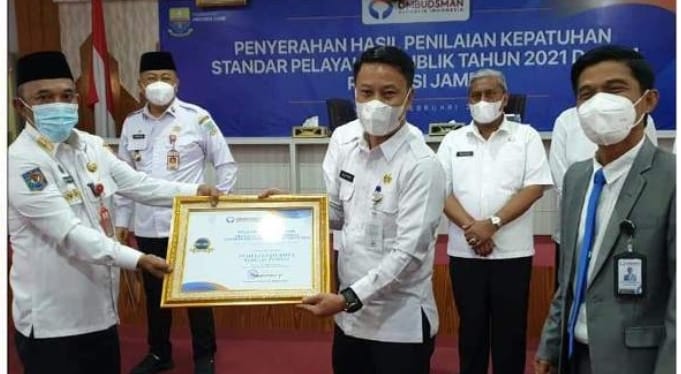 Pj. Sekda Alpian, S.E., MM saat menerima penghargaan peringkat 1 kepatuhan pelayanan publik.