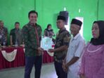Bupati Batang Hari M. Fadhil Arief menyerahkan sertifikat tanah program PTSL kepada warga Desa Kilangan dan Desa Singkawang Kecamatan Muara Bulian