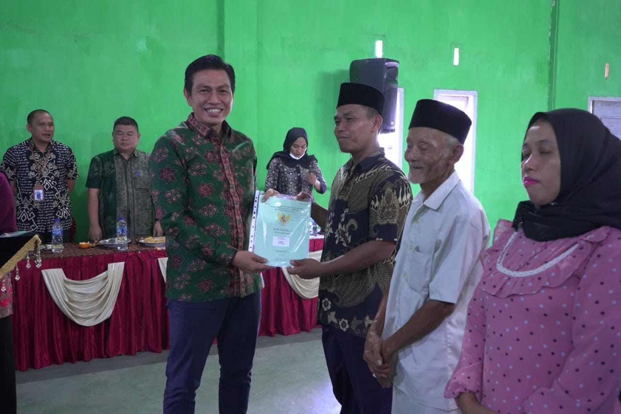 Bupati Batang Hari M. Fadhil Arief menyerahkan sertifikat tanah program PTSL kepada warga Desa Kilangan dan Desa Singkawang Kecamatan Muara Bulian