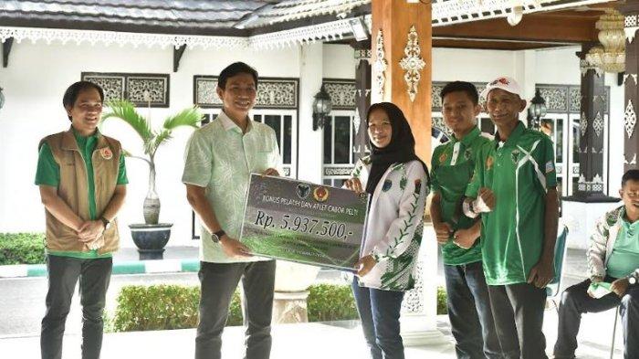 Bupati Batanghari M. Fadhil Arief menyerahkan bonus kepada sejumlah pelatih, official, atlet yang berprestasi