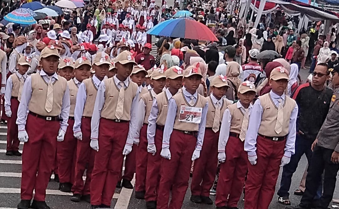 Siswa SDN 56/1 Desa Aro saat mengikuti pawai pembangunan HUT ke-80 RI yang digelar Pemkab Batang Hari di lokasi destinasi wisata Aek Meliuk Muara Bulian.